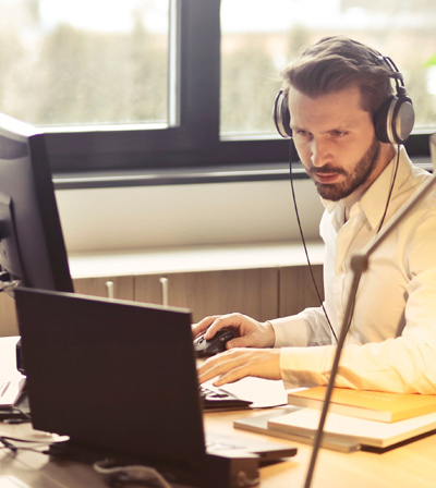 Man with headset glaring at computer